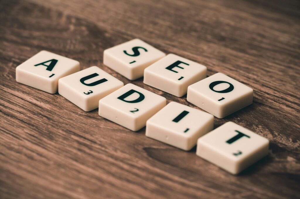Scrabble tiles spelling SEO Audit on wooden surface, symbolizing digital marketing strategies for uptwndev